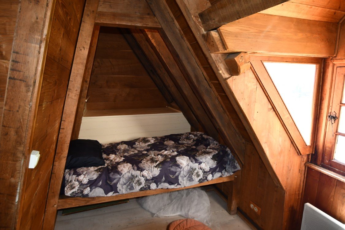 childs bed in a little wooden vestibule