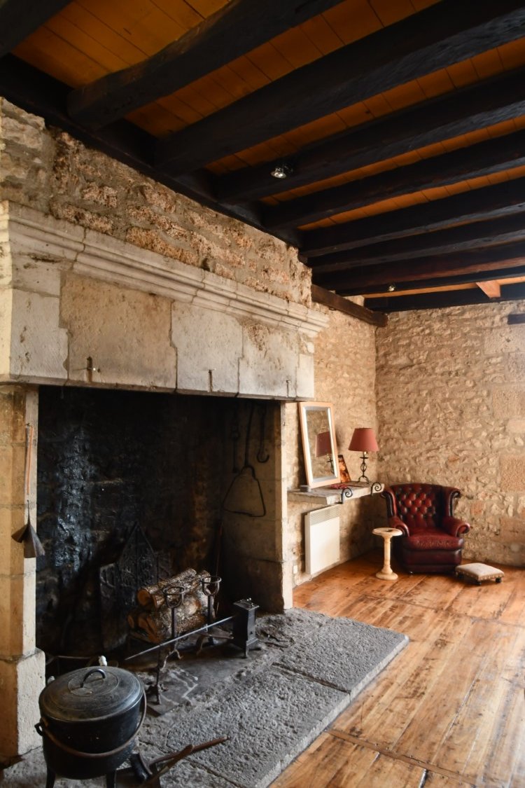 fireplace made of large pale interlocking stones. Looks like a good fire was had last night.