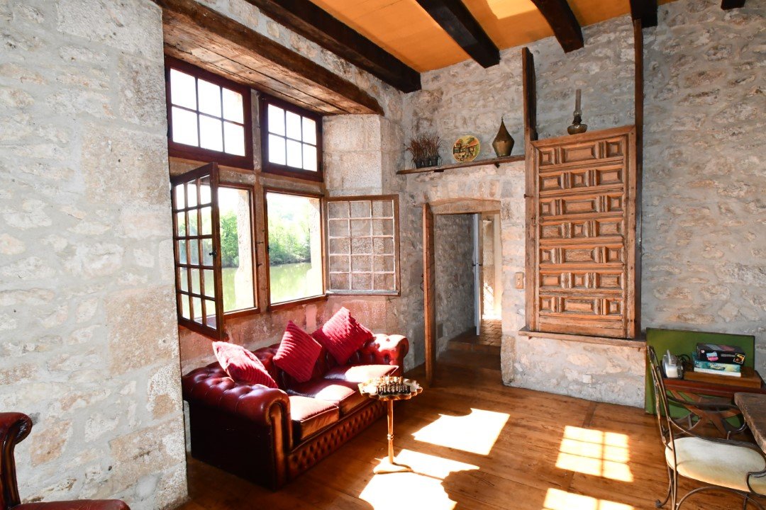 warm sunshine pours through a large stone window into a beautiful room